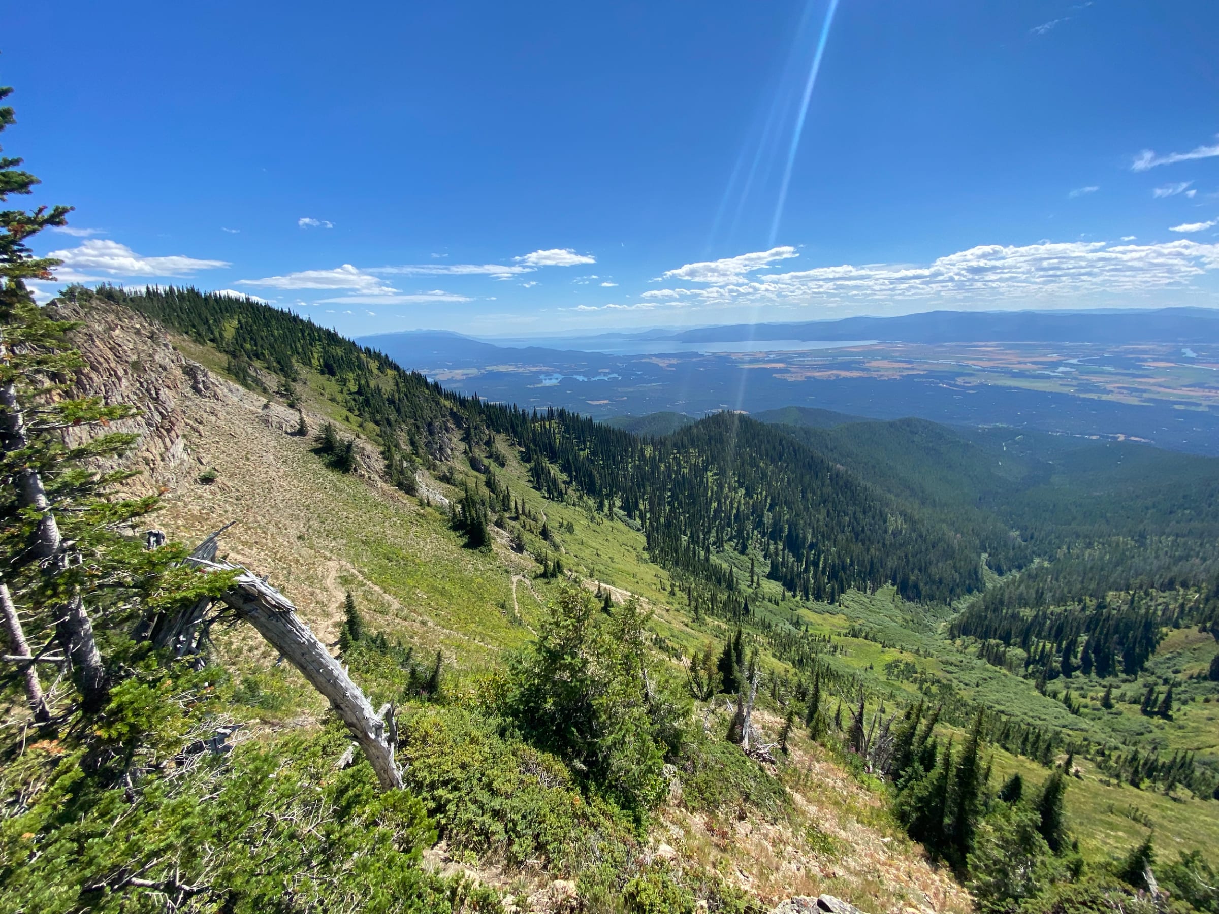 A hiker on the Alpine 7 trail above a valley lake