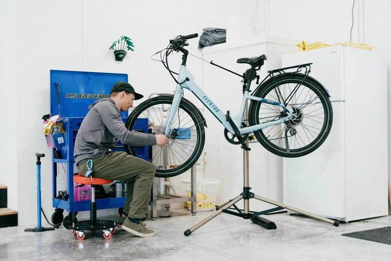 A mechanic tuning an e-bike on the stand in the shop