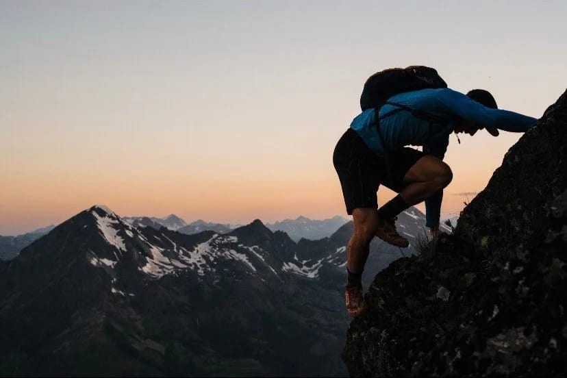 A climber on a ridge at sunrise