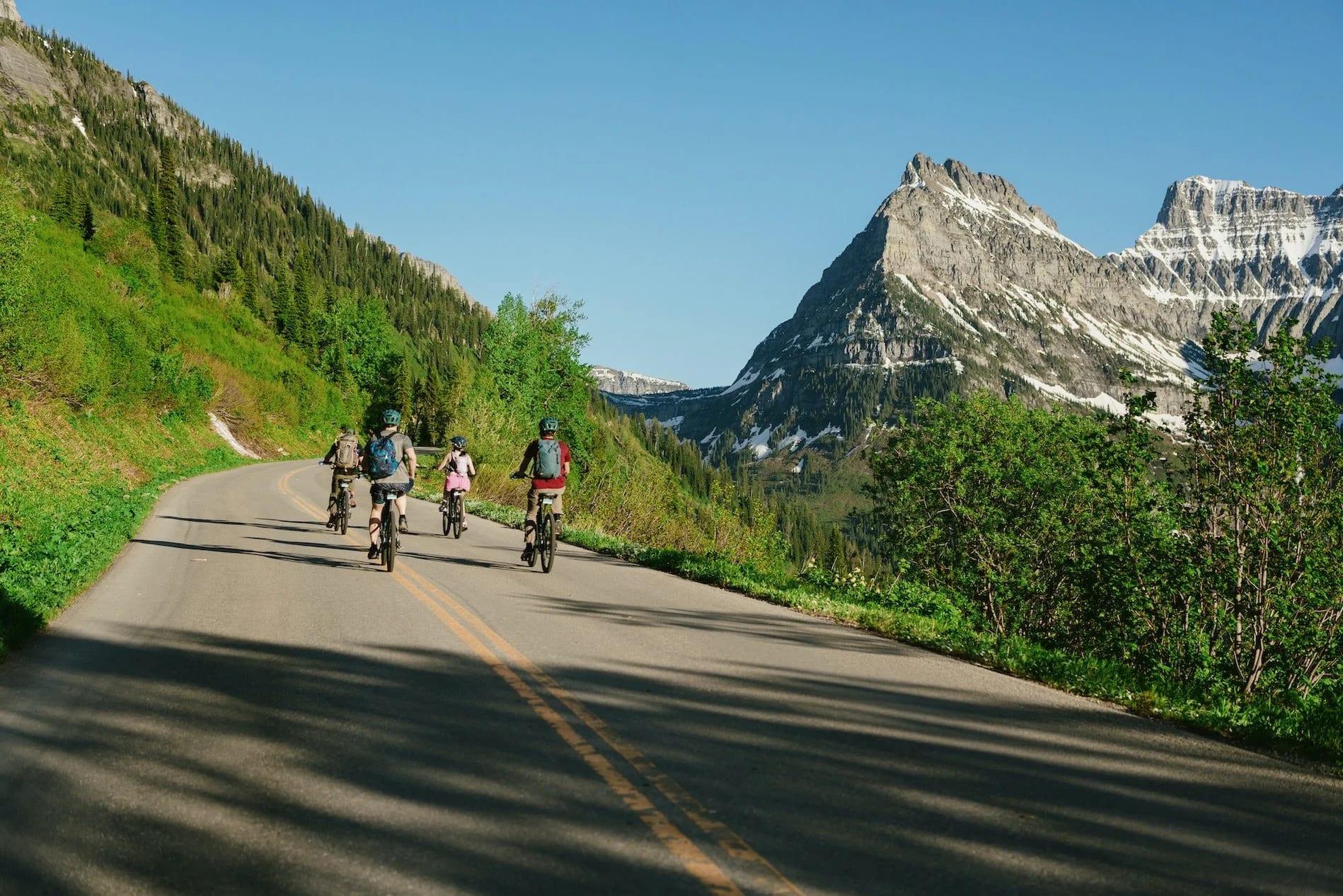 Four guests on e-bikes riding together on Going-to-the-Sun Road