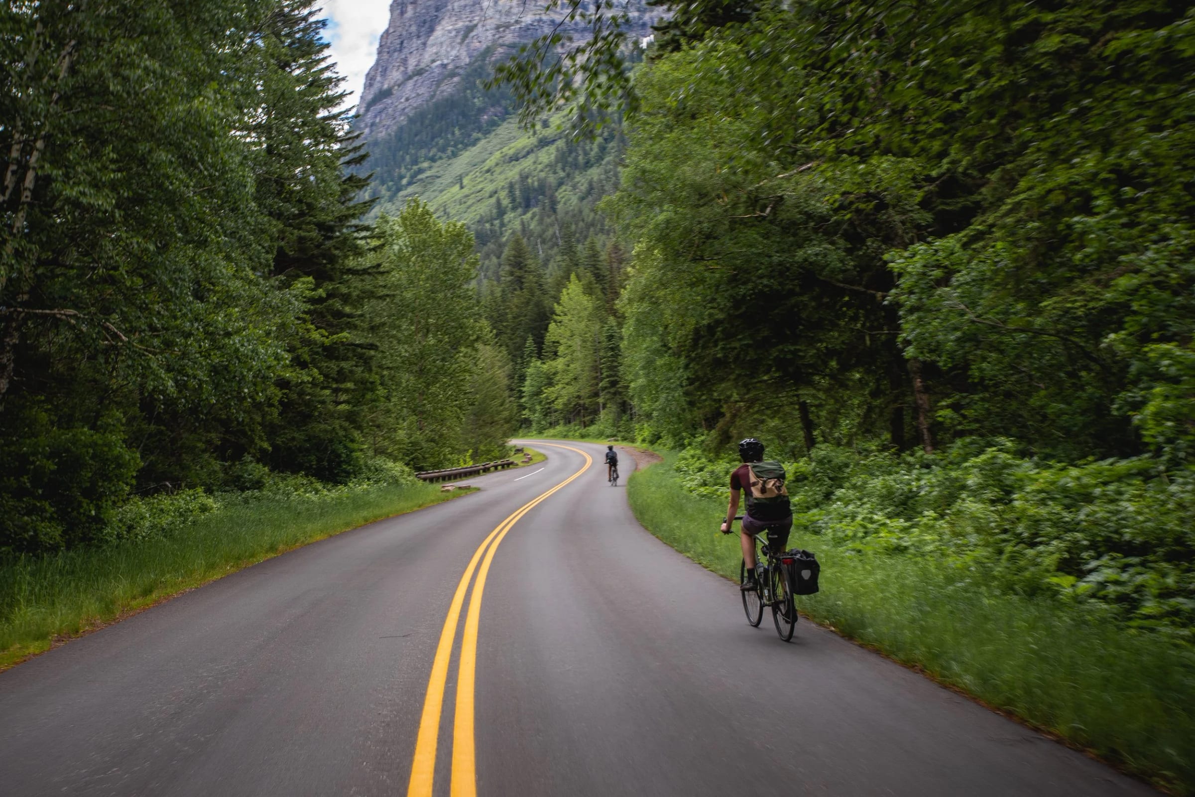 Riders on a road through the forest in Glacier National Park