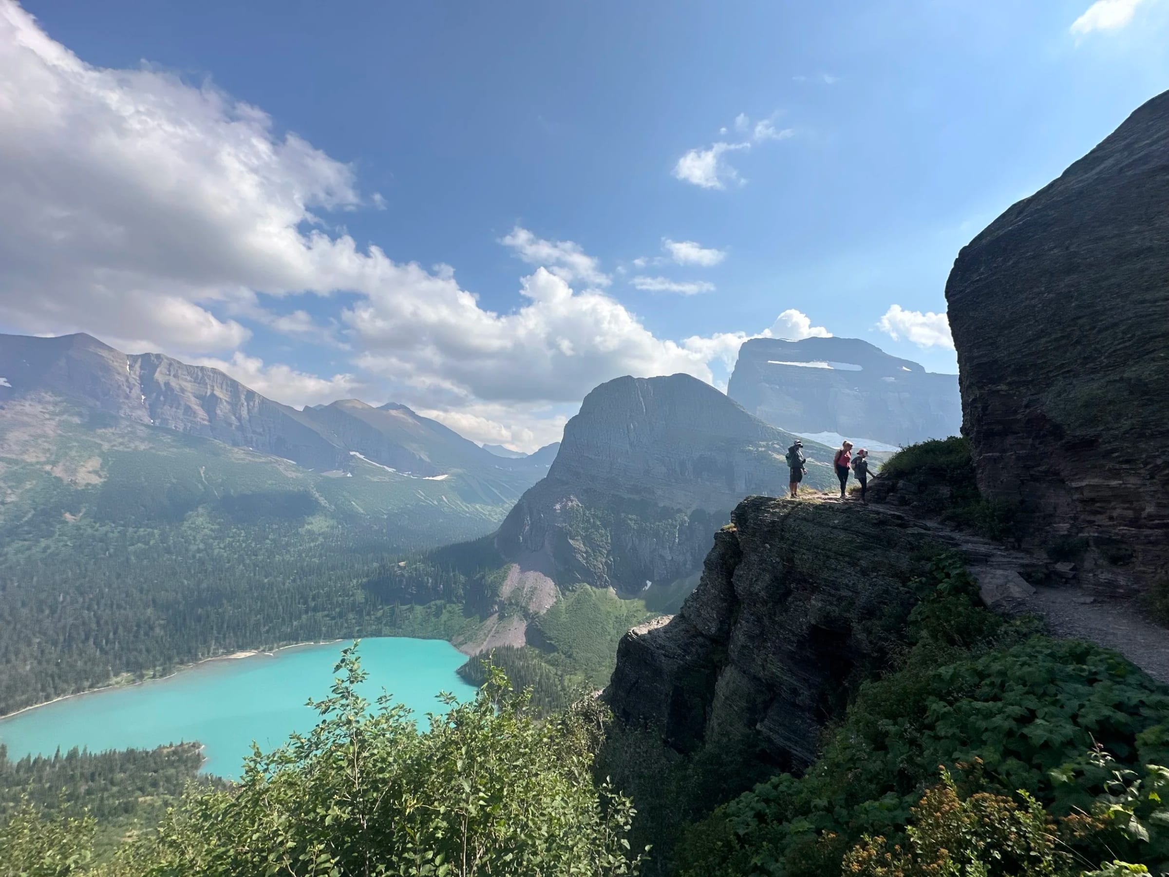 Hikers on a ridge above a mountain lake