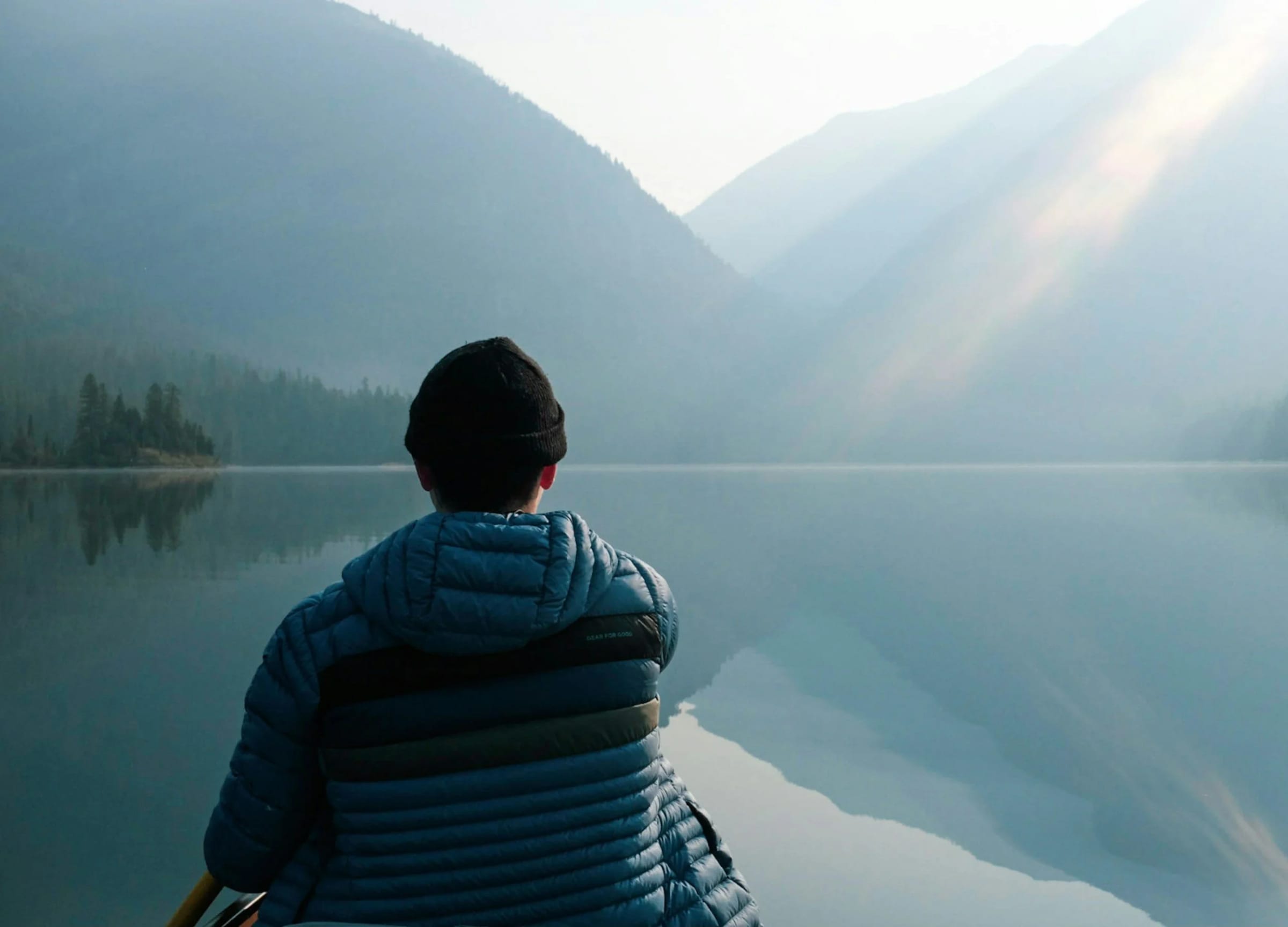 A hiker at the shore of an alpine lake