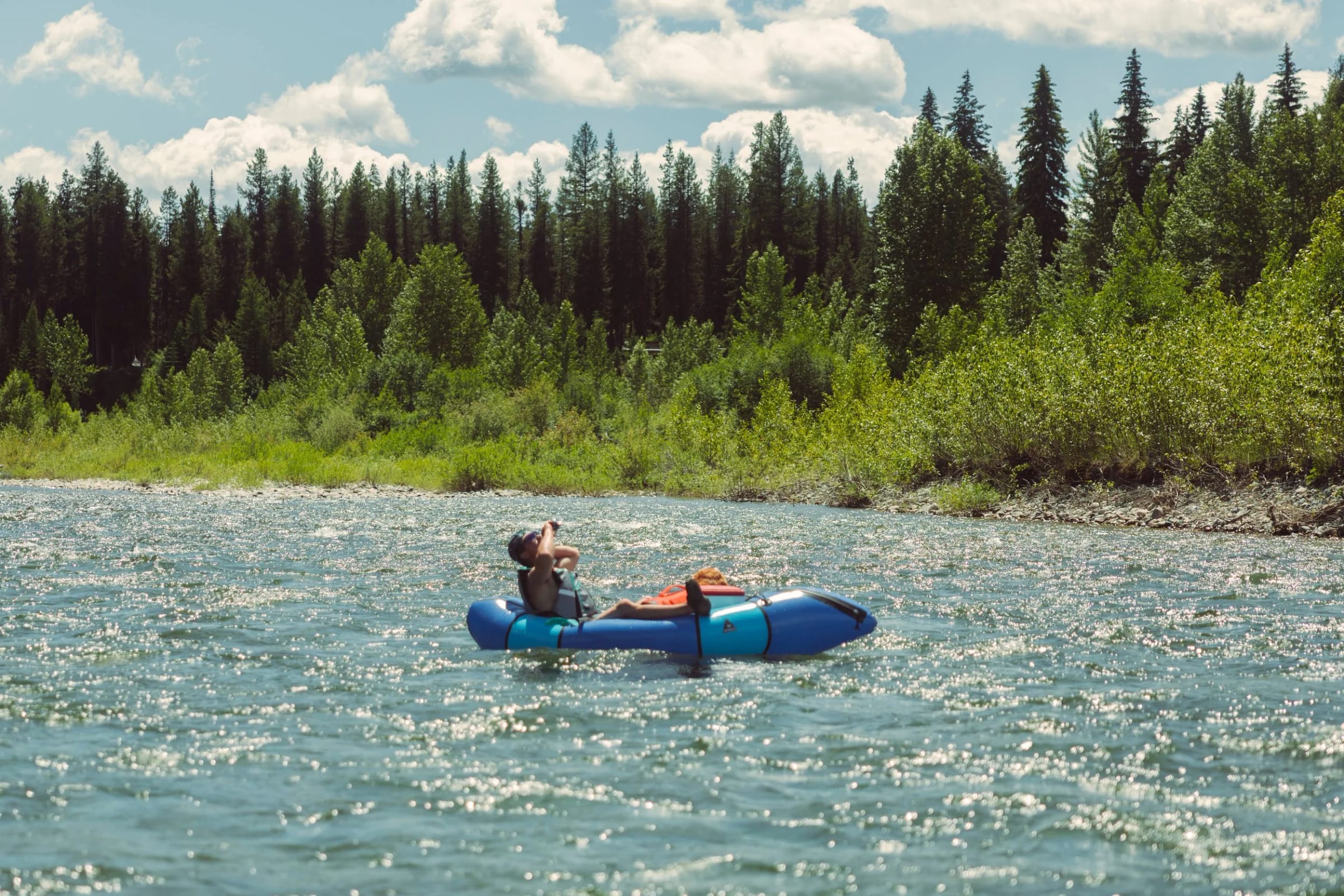 A packrafter on a clear river