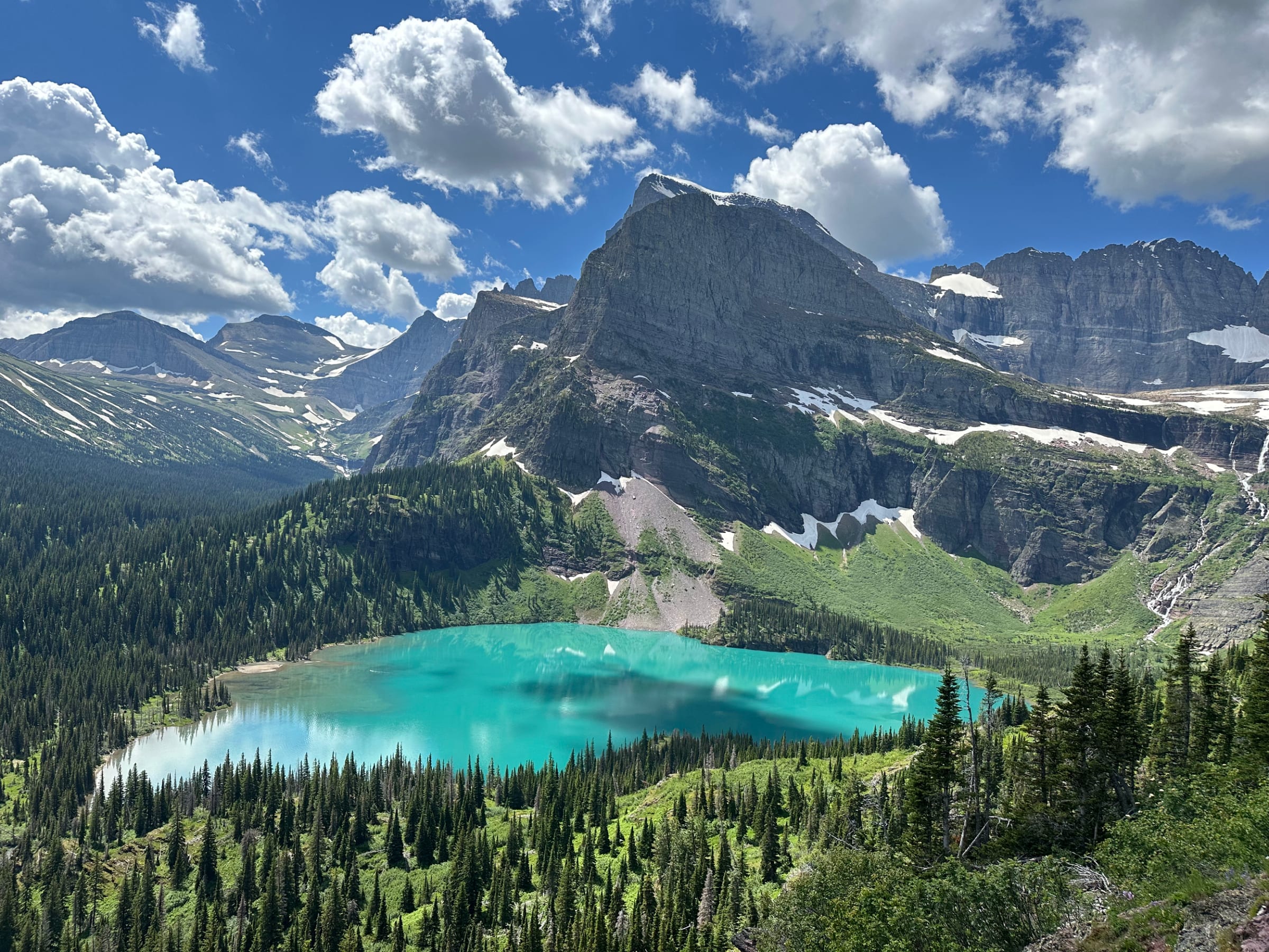 Grinnell Lake's turquoise water below the peaks of Many Glacier