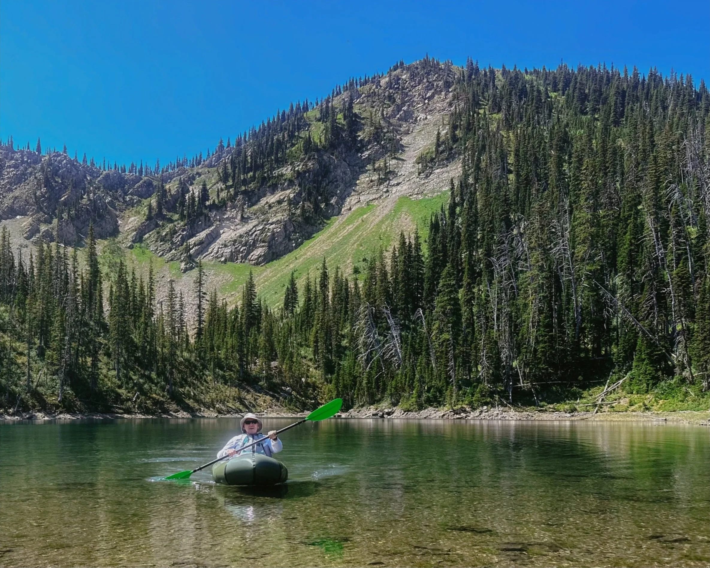A kayaker on a calm mountain lake