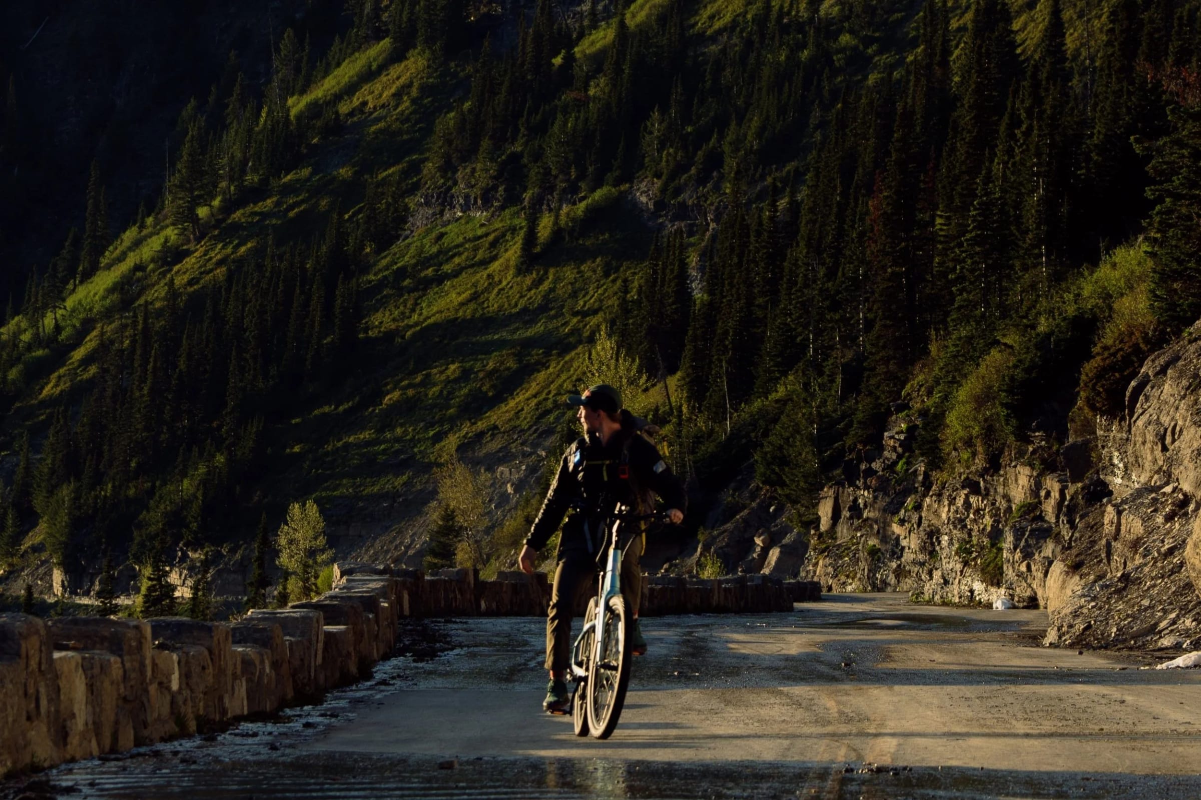 Riders on e-bikes with Going-to-the-Sun Road climbing behind them