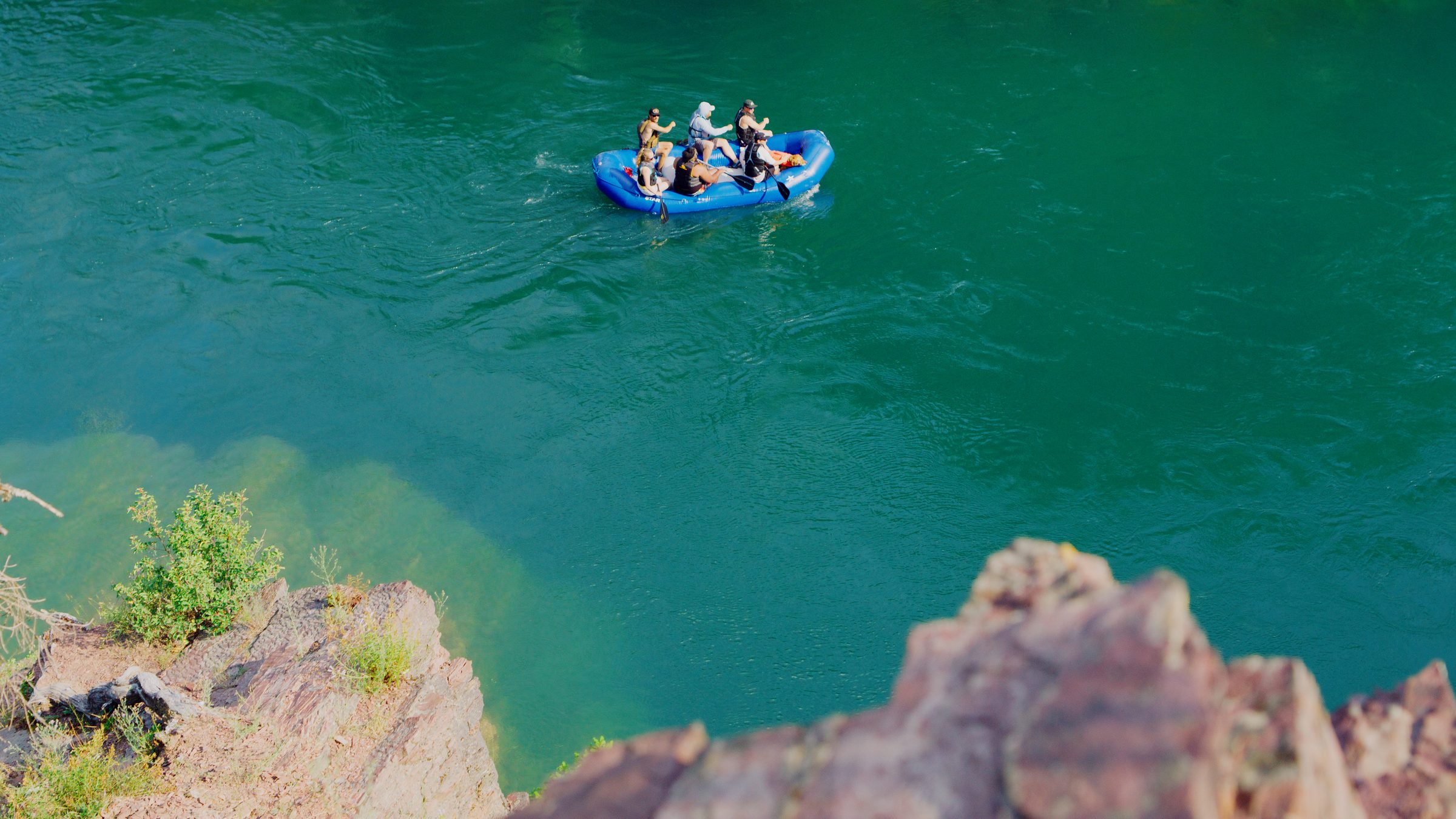 A raft on clear green water seen from above